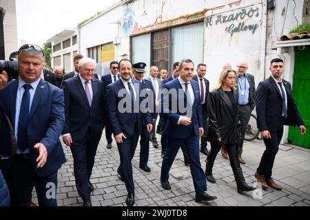 12 febbraio 2024, Cipro, Nikosia: Il presidente federale Frank-Walter Steinmeier (l) e Nikos Christodoulides (M), presidente della Repubblica di Cipro, insieme a Constantinos Yiorkadjis (r), sindaco di Nicosia, camminano dal municipio fino alla "linea verde". La "linea verde” è la zona cuscinetto demilitarizzata monitorata dalle Nazioni Unite (ONU) tra Cipro del Nord occupata dalla Turchia e la Repubblica di Cipro. 20 anni dopo l'adesione del paese all'Unione europea (UE) e 50 anni dopo la divisione dell'isola, il presidente Steinmeier è il primo presidente federale tedesco a visitare il paese Foto Stock