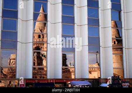 Bastione dei pescatori riflesso nelle finestre dell'Hilton Hotel, quartiere del Castello, Var, Budapest, Ungheria Foto Stock