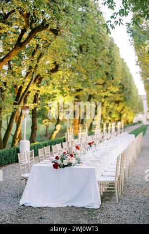 Nel parco si trova un tavolo con mazzi di fiori e candele accese Foto Stock