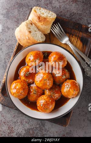 Polpette di pollo affumicate, piccanti e dolci, preparate con la nostra salsa barbecue al miele Chipotle, in primo piano sulla ciotola sul tavolo. Vista dall'alto verticale Foto Stock