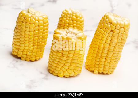 Pezzi di mais su un banco cucina in marmo bianco in una vista dall'alto Foto Stock