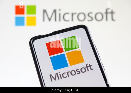 Logo Microsoft della società del software sullo schermo di un telefono cellulare e di un computer Foto Stock