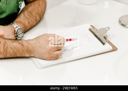 Vista dettagliata della mano di un chirurgo estetico che punta su un documento, che illustra la consultazione professionale e il processo decisionale Foto Stock