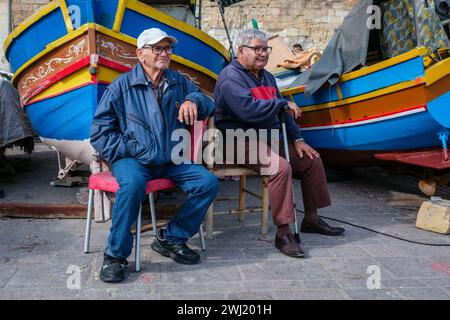 Francis e Johnnie guardano il mondo passare, Marsaxlokk, Malta, 2024 Foto Stock