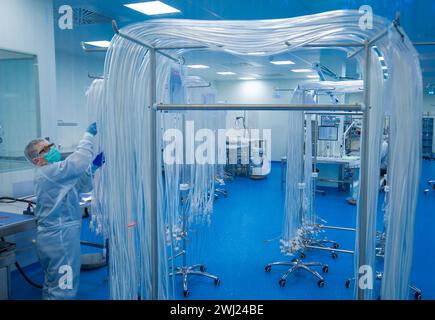 Schwerin, Germania. 12 febbraio 2024. Nella camera bianca dell'azienda Human Med AG, i tubi sono preparati per l'assemblaggio in dispositivi medici per la liposuzione. La società con sede a Schwerin e l'Università e Centro medico Rostock stanno lavorando insieme su questo progetto. Il dispositivo utilizza vibrazioni o un getto d'acqua per aspirare il grasso dal corpo umano e viene utilizzato nel trattamento chirurgico del lipedema, un disturbo della distribuzione del grasso. Crediti: Jens Büttner/dpa/Alamy Live News Foto Stock