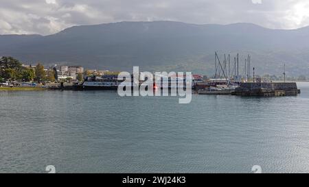 Ohrid, Macedonia del Nord - 23 ottobre 2023: Navi turistiche ormeggiate e barche a vela presso Marina Port Lago di Ohrid, giorno d'autunno. Foto Stock