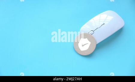 Concetto di tecnologia Internet, sicurezza informatica, database, privacy dei dati e protezione web mouse concept.Computer con un simbolo di scudo in legno. Foto Stock