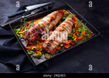 Filetto di maiale mangalica arrosto ripieno di noci tritate e zucca e avvolto in pancetta servito con verdure come clos Foto Stock