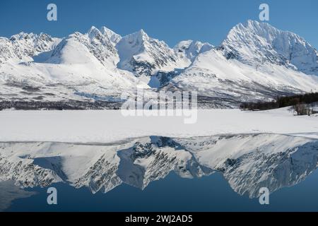 Riflesso di montagne innevate sull'oceano Foto Stock