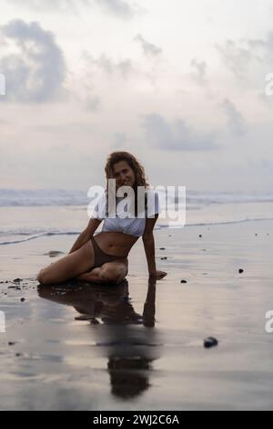 Ritratto di una donna allegra giovane e felice di capelli ricci sulla spiaggia. Bali Foto Stock