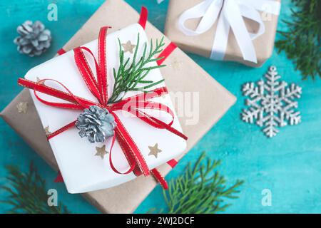 Diverse scatole di Natale di doni addobbate a festa su un sfondo turchese, il fuoco selettivo Foto Stock