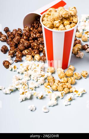 Popcorn assortiti in set di strisce di carta bianco rosso coppa. Il dolce e il salato di popcorn. Foto Stock