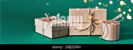 Banner natalizio con una composizione sostenibile di scatole regalo su sfondo verde. Natale zero sprechi, giorno di pugilato e inverno holida Foto Stock