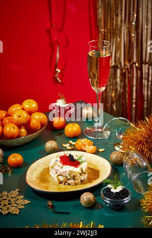 Tavolo di Capodanno o di Natale per feste in stile russo con champagne in bicchiere, mandarini e insalata Olivier in porzioni Foto Stock