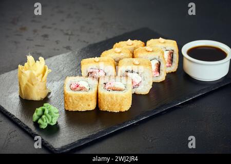 Stuzzica i panini di sushi caldi con salmone su sfondo scuro. Menu sushi. Cibo giapponese. Foto Stock