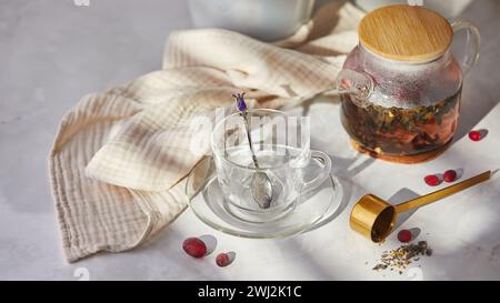 Frutta e tè alle bacche. Preparazione. Svuotare la teiera in vetro e la tazza sul tavolo Foto Stock