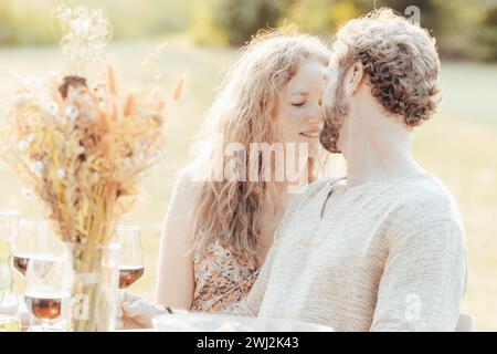 Momento intimo a un tavolo illuminato dal sole Foto Stock