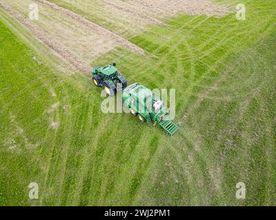 Agricoltura nel Regno Unito. Fotografia aerea con drone di John Deere, trattore, fienagione nell'Hampshire Foto Stock