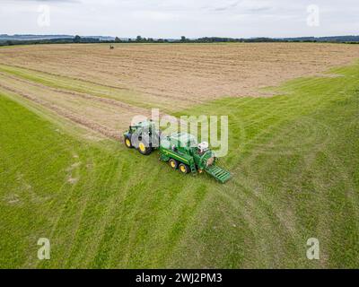 Agricoltura nel Regno Unito. Fotografia aerea con drone di John Deere, trattore, fienagione nell'Hampshire Foto Stock