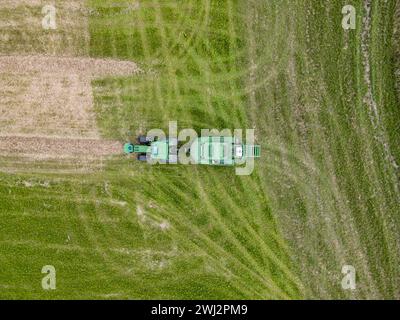 Agricoltura nel Regno Unito. Fotografia aerea con drone di John Deere, trattore, fienagione nell'Hampshire Foto Stock