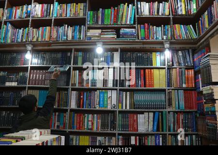 Srinagar, Kashmir, India. 12 febbraio 2024. Un libraio Kashmiri aggiudica i libri nella sua libreria "bestseller" a Srinagar. Per la prima volta una libreria in Kashmir sta rivoluzionando l'accesso alla letteratura offrendo libri a 500 rupie. Il 12 febbraio 2024 a Srinagar nel Kashmir, India. (Immagine di credito: © Firdous Nazir/eyepix via ZUMA Press Wire) SOLO PER USO EDITORIALE! Non per USO commerciale! Foto Stock