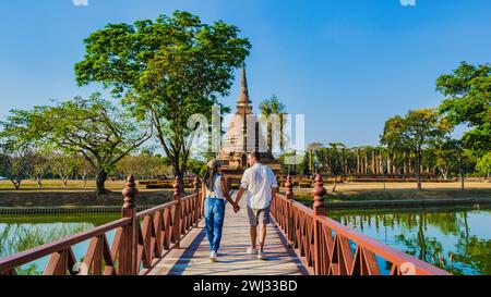 Un paio di uomini e donne che visitano Wat sa si, la città vecchia di Sukhothai, Thailandia, e il parco storico di Sukothai Foto Stock