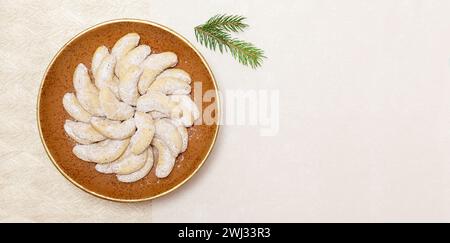 Biscotti alla vaniglia appena sfornati. Cibo dolce tedesco - Vanillekipferl con zucchero vaniglia in polvere. Piano del tavolo Foto Stock