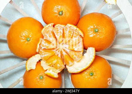 mandarino d'arancia, mandarino, clementine, intero e sbucciato, maturi in un recipiente. vista dall'alto. sbucciate, oran Foto Stock