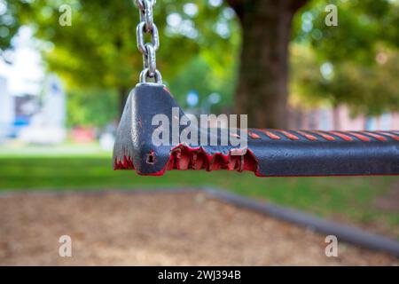 Attrezzatura rotta al parco giochi. Primo piano di altalena vuota nel parco giochi per bambini. fusa dal fuoco. plas Foto Stock