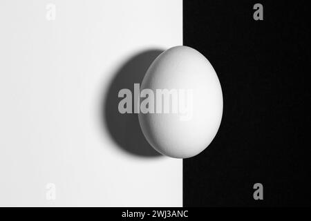 Schermo diviso in bianco e nero con uova e ombre con spazio di copia Foto Stock