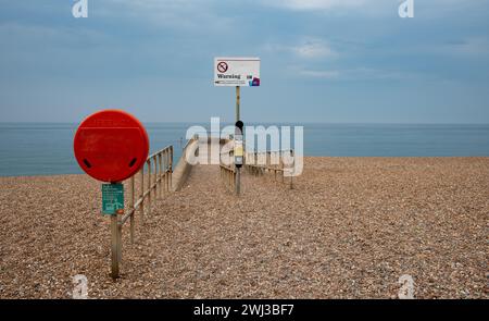 Cartello segnaletico per mare pericoloso su un molo di una costa. Costa di Brighton, Oceano Atlantico Foto Stock