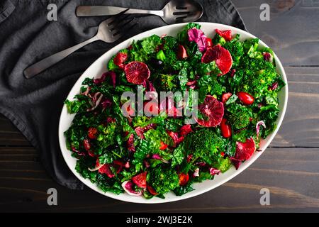 Blood Orange and Tuscan Kale Salad Arranged on a Large Platter: Fresh salad made with kale, broccoli, and radicchio topped with olive oil dressing Stock Photo