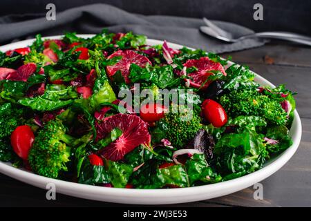 Blood Orange and Tuscan Kale Salad Arranged on a Large Platter: Fresh salad made with kale, broccoli, and radicchio topped with olive oil dressing Stock Photo