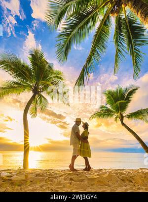 Spiaggia di Bang Tao Phuket Thailandia, coppia di uomini e donne che guardano il tramonto sulla spiaggia Foto Stock