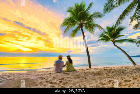 Spiaggia di Bang Tao Phuket Thailandia, coppia di uomini e donne che guardano il tramonto sulla spiaggia Foto Stock