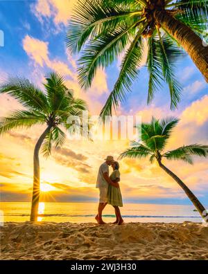 Spiaggia di Bang Tao Phuket Thailandia, coppia di uomini e donne che guardano il tramonto sulla spiaggia Foto Stock