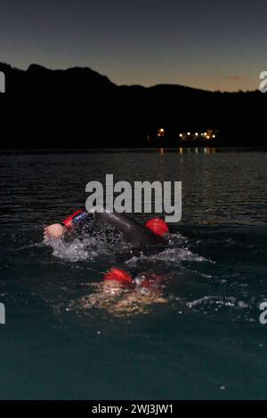 Un determinato triatleta professionista è sottoposto a rigorosi allenamenti notturni nelle acque fredde, dimostrando dedizione e resilienza Foto Stock