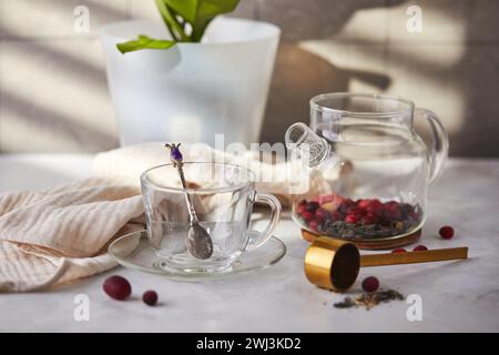 Frutta e tè alle bacche. Preparazione. Svuotare la teiera in vetro e la tazza sul tavolo Foto Stock