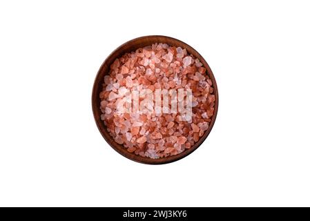 Sale rosa dell'himalaya in una ciotola di legno su uno sfondo di cemento scuro Foto Stock