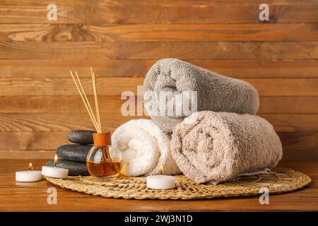 Composizione spa con candele accese su tavolo di legno Foto Stock