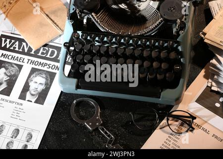 Macchina da scrivere retrò, polsini, occhiali da vista e file criminali su sfondo scuro Foto Stock