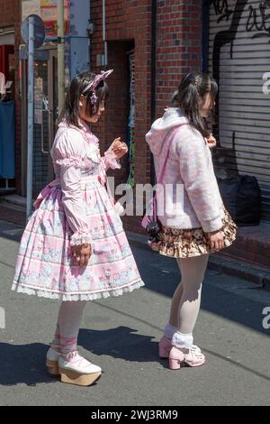 Due ragazze vestite ad Harajuku con abiti rosa in stile Lolita con accessori e trucco. Foto Stock