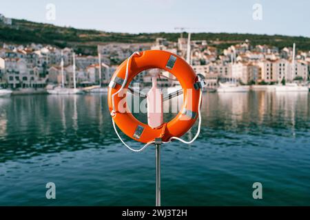 Lifebuoy con corde appese a un cavalletto di metallo sul molo Foto Stock