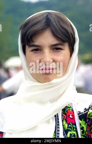 Ritratto di una giovane donna che indossa abiti tradizionali fatti a mano in una fiera di campagna nella contea di Vrancea, Romania, circa 1999 Foto Stock