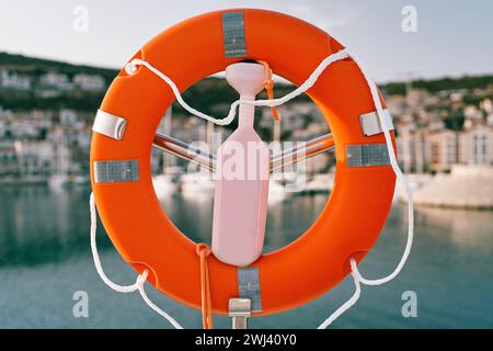 Lifebuoy su un palo d'acciaio con una serratura in riva al mare Foto Stock
