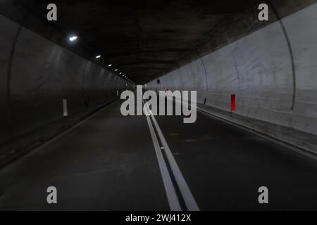 Veduta di un tunnel e di un'autostrada che conduce attraverso una montagna nella regione Abruzzo d'Italia Foto Stock