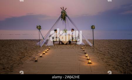 Cena romantica in spiaggia, cena in luna di miele in spiaggia al tramonto in Thailandia, ambiente di San Valentino Foto Stock