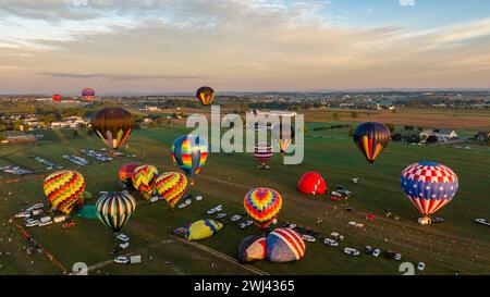 Vista aerea di più mongolfiere che volano durante un lancio mattutino in un giorno estivo di sole Foto Stock