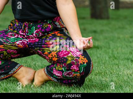 Le ragazze indossano lo yoga in posa su prato verde primo piano Foto Stock