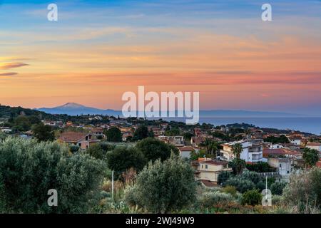 Vista del villaggio di Ricadi in Calabria all'alba con la Sicilia e l'Etna sullo sfondo Foto Stock